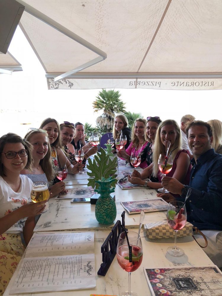 Gruppenfoto des Teams beim gemeinsamen Anstoßen in einem Restaurant auf Mallorca